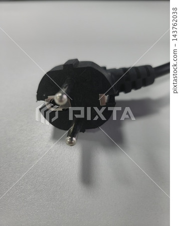 Black electrical power plug on light surface close up Black electrical power plug on light surface close up 143762038
