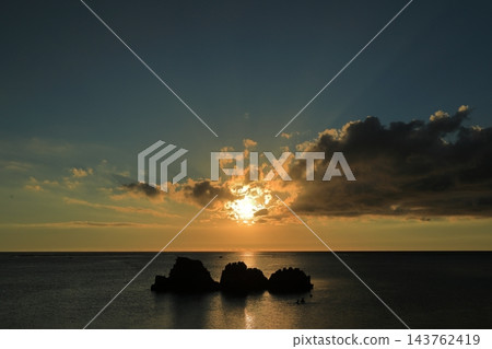 沖繩荒羽海灘,太陽從雲層中升起的景象。 沖繩荒羽海灘,太陽從雲層中升起的景象。 143762419