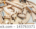 Wooden toy train tracks and railway construction pieces scattered on white background 143763371