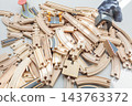 Wooden toy train tracks and railway construction pieces scattered on white background 143763372