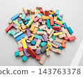 Colorful wooden building blocks scattered on white background for early childhood education 143763378