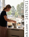 Woman making dough with stand mixer for baking at home kitchen 143763711