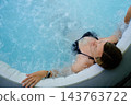 Woman relaxing in bubbling hot tub with eyes closed 143763722