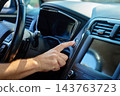 Hand pressing engine start button inside car 143763723