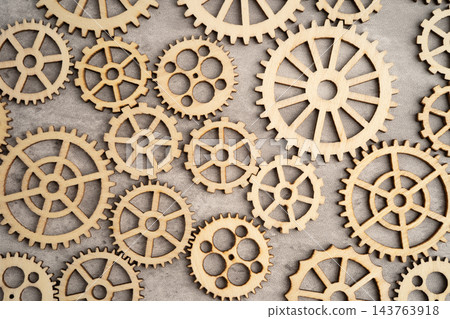 Interlocking wooden gears symbolize teamwork in business. Interlocking wooden gears symbolize teamwork in business. 143763918