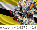 Brunei Darussalam flag with soldier holding assault rifle 143764418