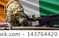 Ivory Coast flag with soldier at machinegun turret 143764420