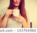 Smiling woman holding cup of tea 143764960