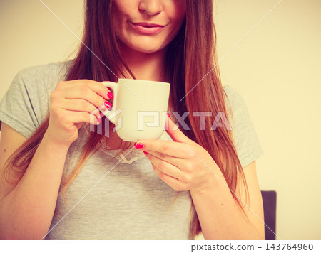 Smiling woman holding cup of tea Smiling woman holding cup of tea 143764960