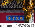 Qixia Ancient Temple in Nanjing China, red wall with blue plaque, golden ginkgo leaves in autum 143765013