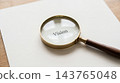 Antique brass magnifying tool with dark wooden handle resting on white paper revealing typed word vision representing classic business strategy and goals 143765048