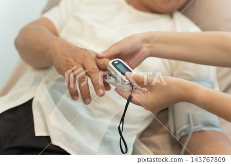 Senior receiving wellness check using pulse oximeter in nursing home. Senior receiving wellness check using pulse oximeter in nursing home. 143767809