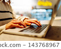 Close-up of hands working on a laptop keyboard. Young woman using laptop computer. Freelance 143768967