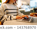 Close-up of hands working on a laptop keyboard. Young woman using laptop computer. Freelance 143768970