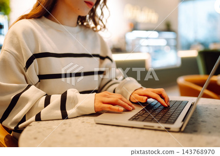 Close-up of hands working on a laptop keyboard. Young woman using laptop computer. Freelance Close-up of hands working on a laptop keyboard. Young woman using laptop computer. Freelance 143768970