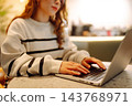 Close-up of hands working on a laptop keyboard. Young woman using laptop computer. Freelance 143768971