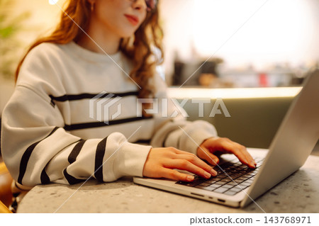 Close-up of hands working on a laptop keyboard. Young woman using laptop computer. Freelance Close-up of hands working on a laptop keyboard. Young woman using laptop computer. Freelance 143768971