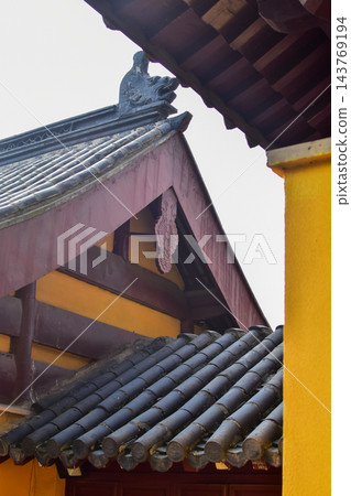 Close-up of the traditional, Chinese classic roof tiles of Chinese building, Chinese architecture in China Garden. Chinese historical building. Travel scene. Building exterior. Close-up of the traditional, Chinese classic roof tiles of Chinese building, Chinese architecture in China Garden. Chinese historical building. Travel scene. Building exterior. 143769194