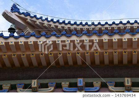 Close-up of the ornate decor on the Chinese classic roof of traditional building, Chinese architecture in China. Chinese folk religion landmark. Buddhist Temple or traditional building. Close-up of the ornate decor on the Chinese classic roof of traditional building, Chinese architecture in China. Chinese folk religion landmark. Buddhist Temple or traditional building. 143769434