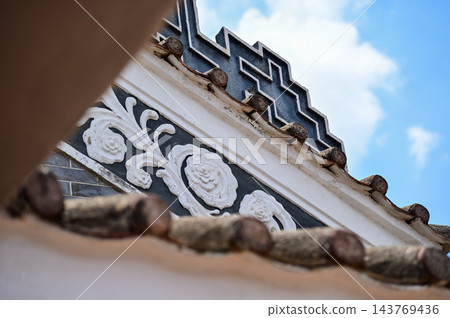 Close-up of the ornate decor on the Chinese classic roof of traditional building, Chinese architecture in China. Chinese folk religion landmark. Buddhist Temple or traditional building. Close-up of the ornate decor on the Chinese classic roof of traditional building, Chinese architecture in China. Chinese folk religion landmark. Buddhist Temple or traditional building. 143769436