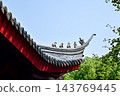 Close-up of the ornate decor on the Chinese classic roof of traditional building, Chinese architecture in China. Chinese folk religion landmark. Buddhist Temple or traditional building. 143769445