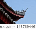 Close-up of the ornate decor on the Chinese classic roof of traditional building, Chinese architecture in China. Chinese folk religion landmark. Buddhist Temple or traditional building. 143769446
