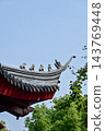 Close-up of the ornate decor on the Chinese classic roof of traditional building, Chinese architecture in China. Chinese folk religion landmark. Buddhist Temple or traditional building. 143769448