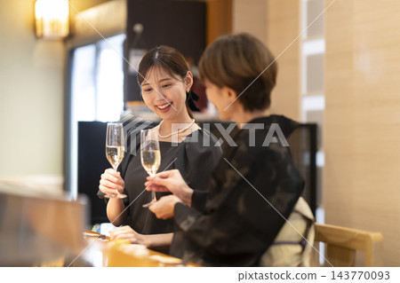 兩名女子在日本餐廳的吧台享用香檳。 143770093