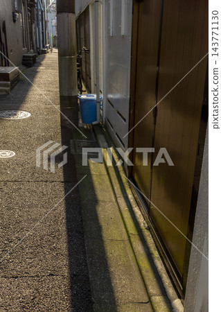 一條兩側有電線桿和垃圾桶的道路 143771130