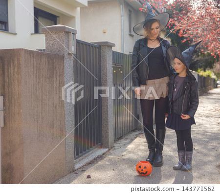 Mother and daughter enjoying Halloween trick or treat in neighborhood Mother and daughter enjoying Halloween trick or treat in neighborhood 143771562