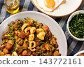 Brazilian feijao tropeiro with sausage, pork rinds and eggs served on a rustic plate on a tablecloth covered table. 143772161