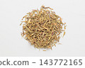 A small mound of dried thyme against a white background, photographed from directly above. 143772165