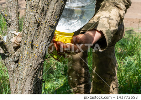 Ukrainian soldier washing hands using an improvised plastic bottle water 143772658