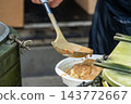 Ukrainian soldiers serving food from thermal containers outdoors 143772667