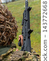 Ukrainian soldier in ghillie helmet holding an assault rifle outdoors 143772668