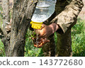 Ukrainian soldier washing hands using an improvised plastic bottle water 143772680