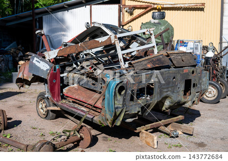 Pile of rusty classic car body panels and metal parts awaiting restoration in automotive salvage yard Pile of rusty classic car body panels and metal parts awaiting restoration in automotive salvage yard 143772684