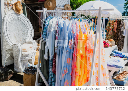Stylish summer clothing collection on outdoor market rack with pastel linen fashion and casual apparel Stylish summer clothing collection on outdoor market rack with pastel linen fashion and casual apparel 143772712