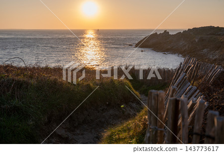 rocky coastline at sunset with ocean waves and golden sunlight over cliffs in scenic coastal landscape 143773617