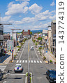 A vertical composition (aspect ratio 2:3) overlooking the main street in front of Fujinomiya Station and the city center, with the summer sky stretching wide. 143774319