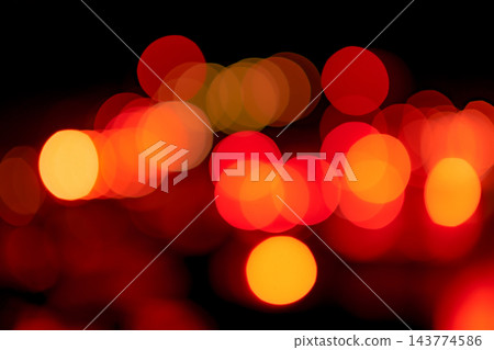 Blur red and orange bokeh on dark background. Abstract background of city light. Bokeh light with pattern of circle bokeh. Red and yellow light on black. Defocused bokeh light in the city at night. Blur red and orange bokeh on dark background. Abstract background of city light. Bokeh light with pattern of circle bokeh. Red and yellow light on black. Defocused bokeh light in the city at night. 143774586