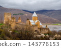 Ananuri Fortress complex with towers, churches and blossoming trees above reservoir in spring, Georgia 143776153