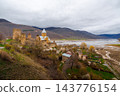 Ananuri Fortress complex with towers, churches and blossoming trees above reservoir in spring, Georgia 143776154