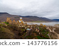 Ananuri Fortress complex with towers, churches and blossoming trees above reservoir in spring, Georgia 143776156