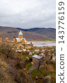 Ananuri Fortress complex with towers, churches and blossoming trees above reservoir in spring, Georgia 143776159