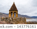 Brick roofed belfry on Ananuri fortress wall overlooking reservoir and misty mountains, Georgia 143776161