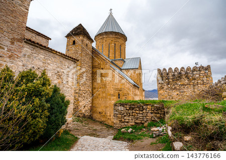 Ananuri church with conical roof, watchtower and cobblestone path in fortress, Georgia Ananuri church with conical roof, watchtower and cobblestone path in fortress, Georgia 143776166