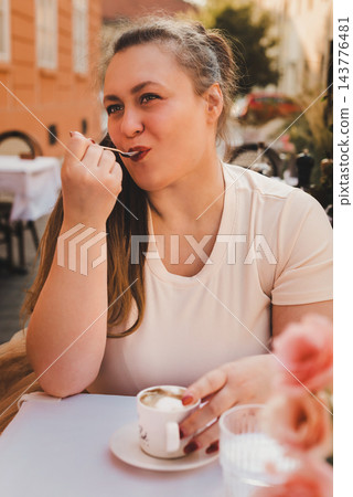 Woman Enjoying Coffee and Dessert at Outdoor Cafe Woman Enjoying Coffee and Dessert at Outdoor Cafe 143776481