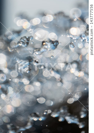 Splashes and jets of water against light background. 143777556
