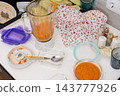 Squash caviar is being prepared on a kitchen counter, with blended squash, a bowl of puree, a blender, and utensils visible during food preparation 143777926